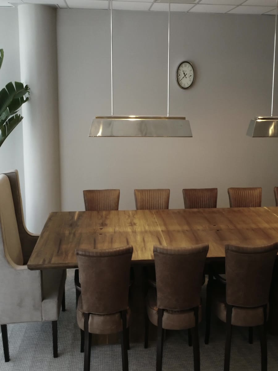 Sala de reuniones con mesa de madera e iluminación colgante
